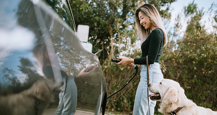 Woman with EV charging port and dog